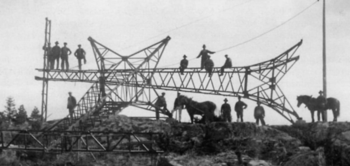 Historisk bild av män som reser en kraftledningsstolpe